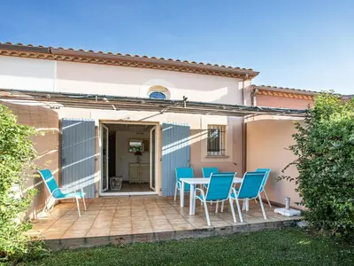 a patio with blue chairs and a table at P Minervois J N03 Villa 3P6 in Homps