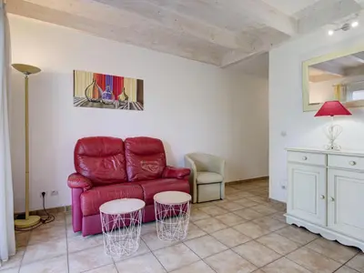 a living room with a red couch and two tables at P Minervois J N03 Villa 3P6 in Homps