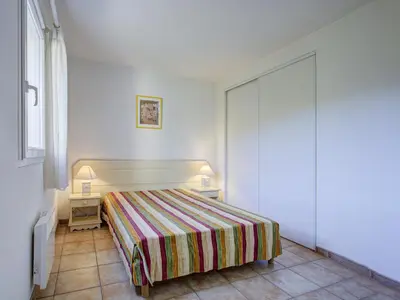 a bedroom with a bed with a striped blanket at P Minervois J N03 Villa 3P6 in Homps