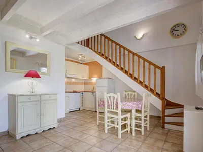 a kitchen with a staircase and a table and chairs at P Minervois J N03 Villa 3P6 in Homps