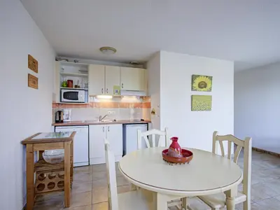 a kitchen with a white table and a table and chairs at P Minervois P N05 Villa 2P4 in Homps