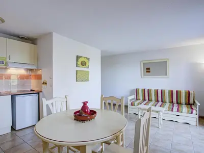 a kitchen and a living room with a table and a couch at P Minervois P N05 Villa 2P4 in Homps