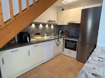 a kitchen with white cabinets and stainless steel appliances at P Minervois G N02 Villa 3P4 in Homps