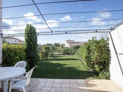 a patio with a table and chairs and a garden at P Minervois C N02 Villa 3P6 in Homps