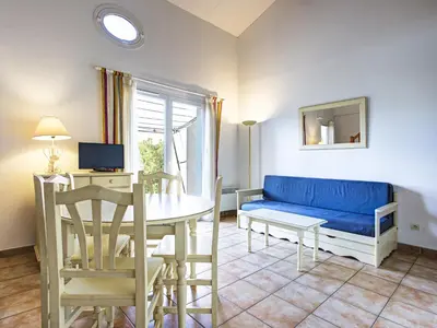 a living room with a blue couch and a table at P Minervois C N02 Villa 3P6 in Homps
