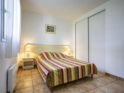 a bedroom with a bed with a striped blanket at P Minervois C N02 Villa 3P6 in Homps
