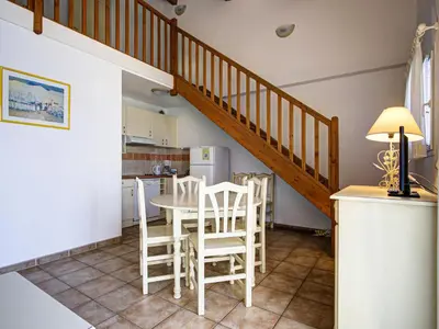a kitchen with a table and chairs and a staircase at P Minervois C N02 Villa 3P6 in Homps