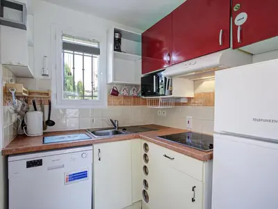 a kitchen with white cabinets and a sink and a refrigerator at P Minervois U N04 VILLA 3P6 in Homps