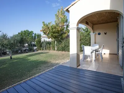 a wooden deck with a table and chairs on a yard at P Minervois U N04 VILLA 3P6 in Homps