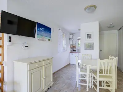 a kitchen and dining room with a table and a tv on the wall at P Minervois U N04 VILLA 3P6 in Homps