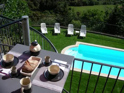 a table with a plate of food next to a pool at Écurie De Cucugnan in Cucugnan