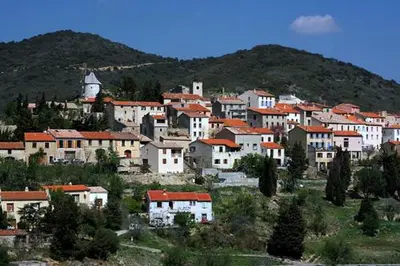 a village with white houses and a mountain at Écurie De Cucugnan in Cucugnan