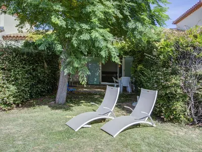 two white chairs sitting in the grass under a tree at Haut du Lac I N205 3P6 in Homps
