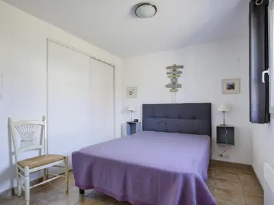 a bedroom with a purple bed and a chair at Haut du Lac I N205 3P6 in Homps