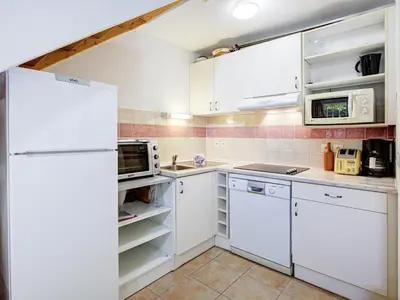 a kitchen with white cabinets and a refrigerator at Haut du Lac I N205 3P6 in Homps