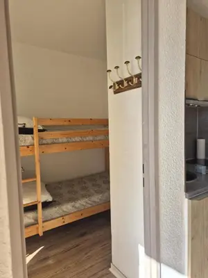 a room with two bunk beds in it at Les pieds dans l'eau Studio Cabine terrasse, refait à neuf 5 minutes plage à pied climatisé in Gruissan
