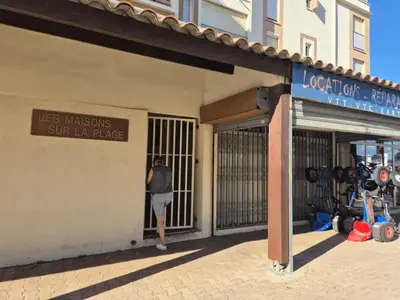 a woman standing in the gate of a store at Les pieds dans l'eau Studio Cabine terrasse, refait à neuf 5 minutes plage à pied climatisé in Gruissan