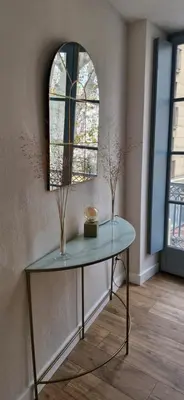 a glass table in a room with a mirror at La Romana in Narbonne