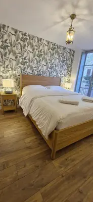 a bedroom with a large bed with a wall at La Romana in Narbonne
