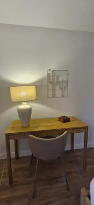 a wooden desk with a lamp and a chair at La Romana in Narbonne