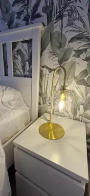 a lamp on a nightstand next to a bed at La Romana in Narbonne