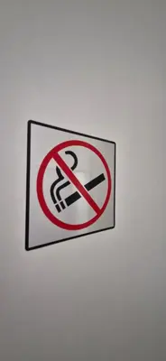 a no smoking sign on a white wall at La Romana in Narbonne