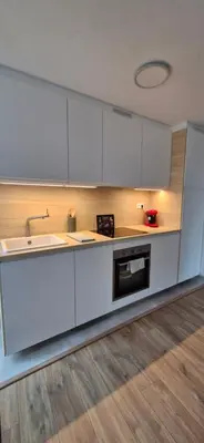 a kitchen with white cabinets and a sink at La Romana in Narbonne