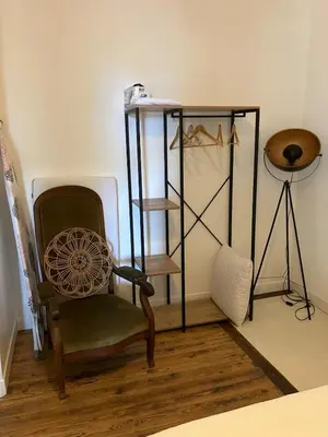 a room with a chair and a shelf with shoes at La Casita du Canal in Castelnaudary