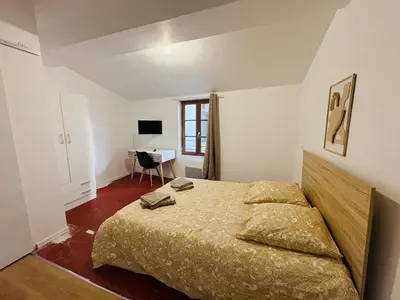 a bedroom with a bed and a desk at La coloc' l 3 Chambres avec salle de bain & TV in Castres