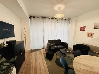 a living room with a couch and a table at La coloc' l 3 Chambres avec salle de bain & TV in Castres