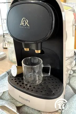 a coffee maker with a cup on a counter at La douce echappee in Trèbes