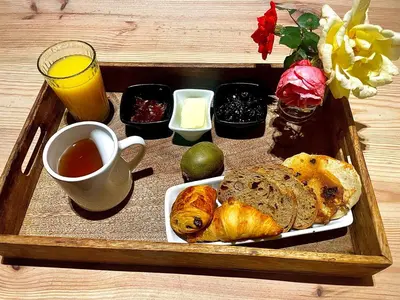 a tray of food with bread and a cup of tea at Las Mijeannos in Cazalrenoux