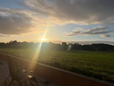 a chair sitting on a porch watching the sunset at Las Mijeannos in Cazalrenoux