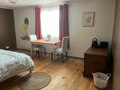 a bedroom with a table and chairs and a bed at Las Mijeannos in Cazalrenoux