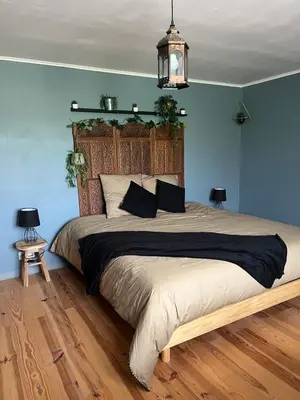 a bedroom with a large bed with blue walls at Las Mijeannos in Cazalrenoux
