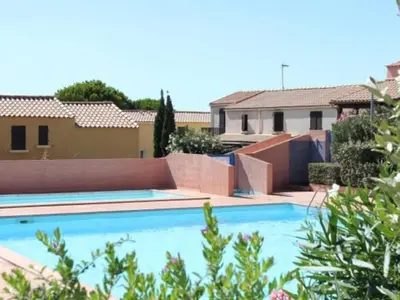 a swimming pool in front of a house at Pavillon moderne & spacieux - accès direct plage in Gruissan