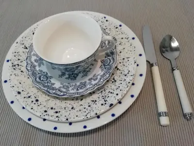 a blue table with plates and wine glasses on it at La maison de la fontaine in Villeneuve-Minervois