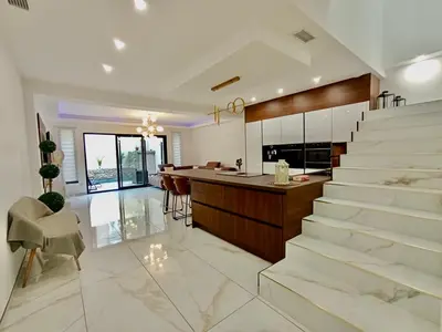 a kitchen and living room with stairs and a counter at Maison de ville - Les Grands Buffets in Narbonne