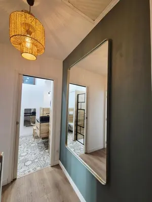 a mirror on the wall of a room with a hallway at Appartement l'Atelier Cosy in Narbonne