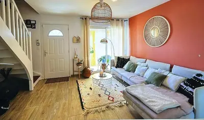 a living room with a blue couch and a red wall at Maison narbonne in Narbonne