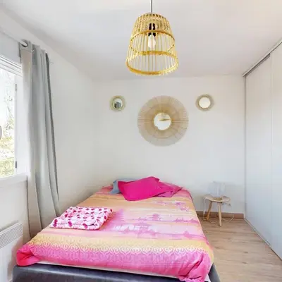 a bedroom with a bed with a pink blanket at Maison narbonne in Narbonne