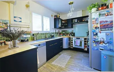 a kitchen with blue cabinets and a refrigerator at Maison narbonne in Narbonne