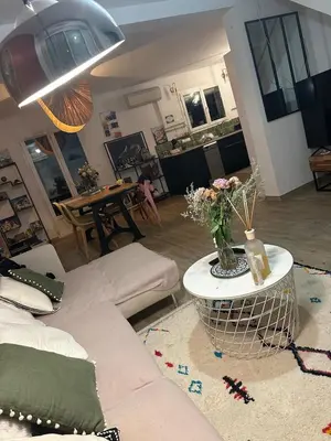 a living room with a couch and a table with flowers at Maison narbonne in Narbonne