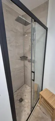 a shower with a glass door in a bathroom at Le Donjon du Chateau in Tournissan