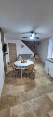 a dining room with a table and chairs in a room at Le Donjon du Chateau in Tournissan