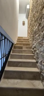 a stairway leading up to a stone wall at Le Donjon du Chateau in Tournissan
