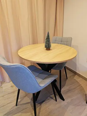 a wooden table with two chairs and a christmas tree on it at Le Cocon de Pezens - Studio au centre du village in Pezens