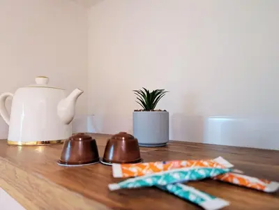 a wooden table with a tea kettle and snacks on it at Le Cocon de Pezens - Studio au centre du village in Pezens