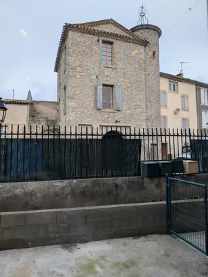 an old building with a black fence in front of it at Le Cocon de Pezens - Studio au centre du village in Pezens