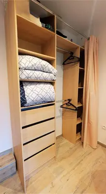 a walk in closet with wooden shelves and a bed at Le Cocon de Pezens - Studio au centre du village in Pezens